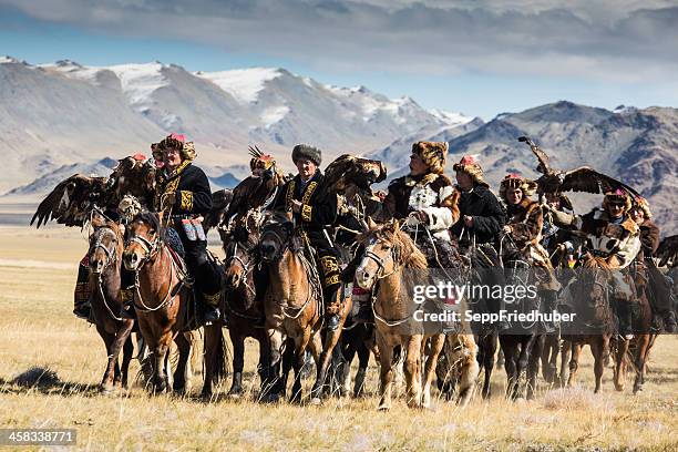 mongolian eagle hunters riding to the festival. - kazakhstan steppe stock pictures, royalty-free photos & images