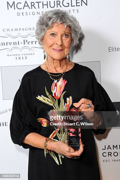 Founder of Browns, CBE Joan Burstein poses with her Lifetime Achievement Award in front of the winners boards at the Walpole British Luxury Awards...