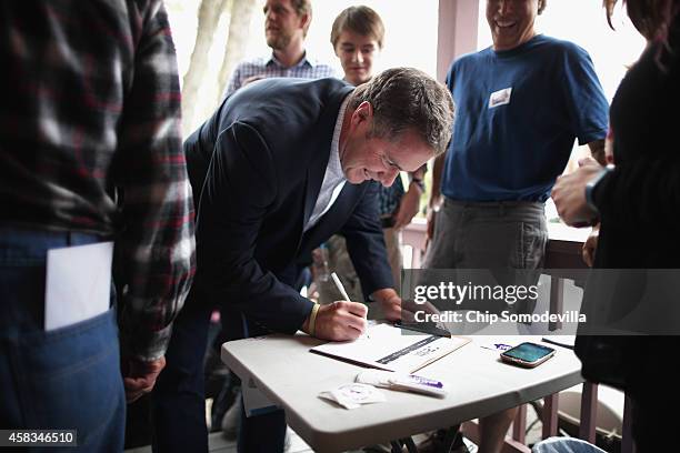 Democratic U.S. Senate candidate Rep. Bruce Braley signs a volunteer roster before kicking off a canvass of the surrounding neighborhood November 3,...