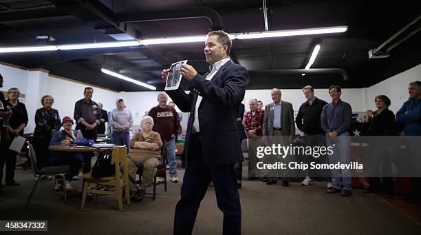 While encouraging volunteers not to give up, Democratic U.S. Senate candidate Rep. Bruce Braley holds a copy of the photograph of President Harry...