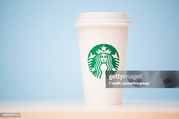 grande starbucks to go cup on table - starbucks coffee stock pictures, royalty-free photos & images