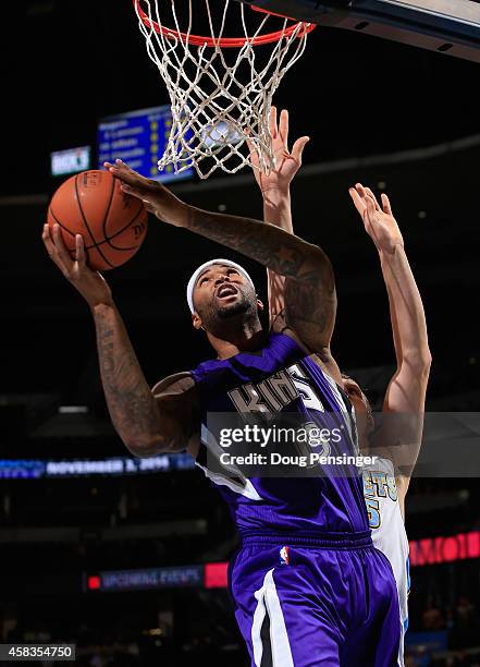 DeMarcus Cousins of the Sacramento Kings lays in a shot against Timofey Mozgov of the Denver Nuggets at Pepsi Center on November 3, 2014 in Denver,...