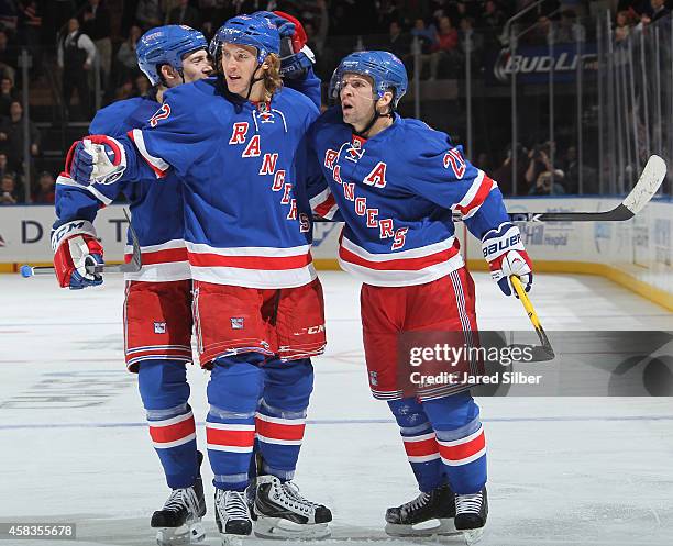 Martin St. Louis, Carl Hagelin and Matt Hunwick of the New York Rangers celebrate after a third period goal against the St. Louis Blues at Madison...