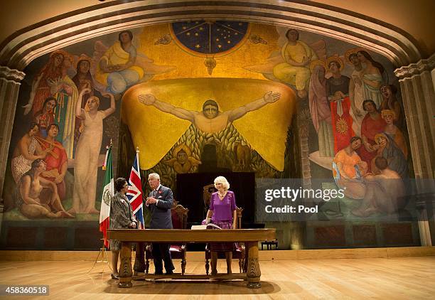 Prince Charles, Prince of Wales and Camilla, Duchess of Cornwall sign the visitor's book in front of a Diego Rivera mural at the launch of 'The Year...