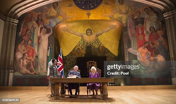 Prince Charles, Prince of Wales and Camilla, Duchess of Cornwall sign the visitor's book in front of a Diego Rivera mural at the launch of 'The Year...