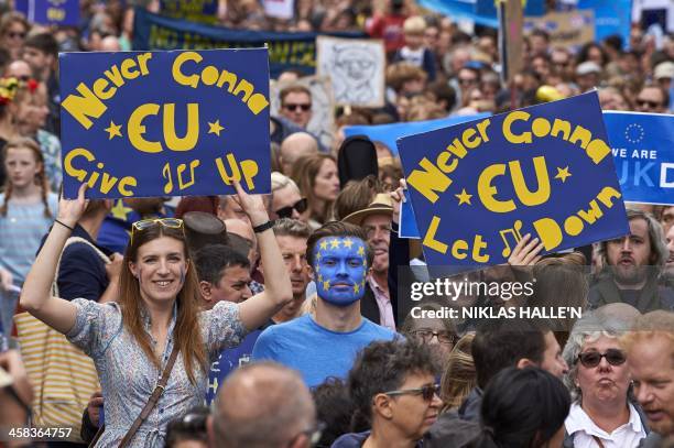 People hold up pro-Europe placards as thousands of protesters take part in a March for Europe, through the centre of London on July 2 to protest...