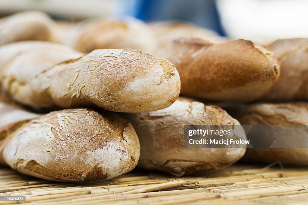 French baguettes stacked on market