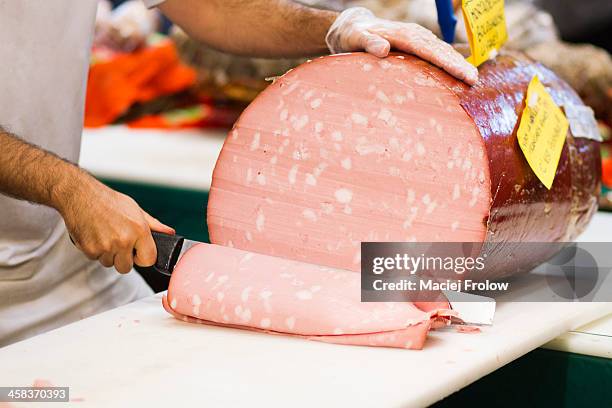 man slicing mortadella at market - mortadella stock pictures, royalty-free photos & images