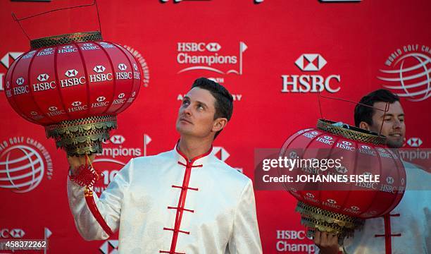 Golfers Justin Rose of England and Adam Scott of Australiawear Chinese costumes and hold lanterns as they attend a photo call for the WGC-HSBC...