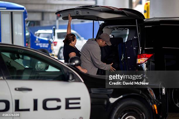 Arriving travelers load their luggage into a car next to a police car at Los Angeles International Airport on July 2, 2016 in Los Angeles,...