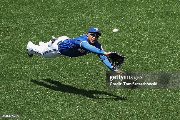 Ezequiel Carrera of the Toronto Blue Jays dives but cannot get to an RBI triple by Rajai Davis of the Cleveland Indians in the third inning during...