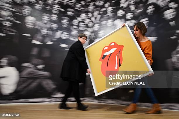 Gallery assistants pose for pictures with John Pasche's 1971 'Tongue and Lip Design' logo, commissioned by Mick Jagger, at a photocall for a...