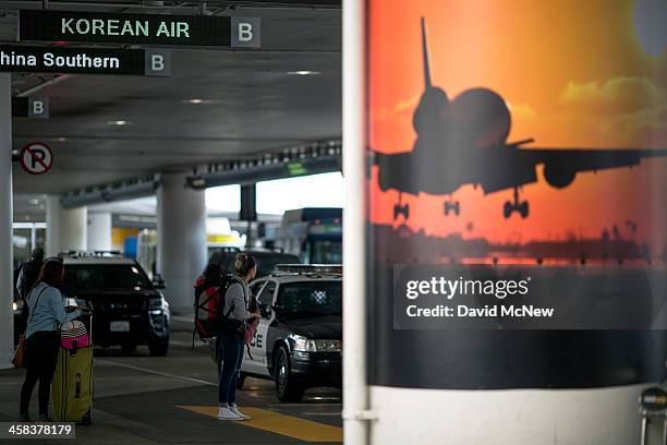 Arriving passengers stand curbside near police cars at Los Angeles International Airport on July 2, 2016 in Los Angeles, California. Security is...