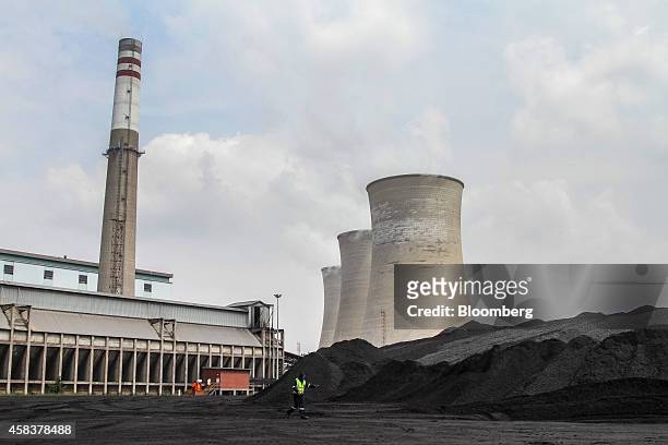 Worker operates near coal stores in the coal yard at the Grootvlei power station, operated by Eskom Holdings SOC Ltd., in Grootvlei, South Africa, on...