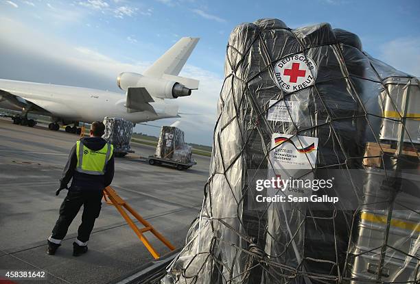 Ground crew worker prepares to load a plane with a 25-ton shipment of tents, generators, air-conditioning units, chlorine for disinfection and other...