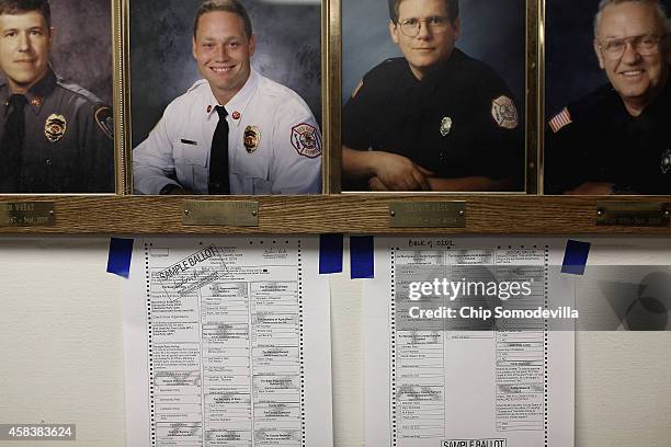 Sample ballots hang on the wall below photos of local firefighters at the Red Oak Fire Department November 4, 2014 in Red Oak, Iowa. According to the...