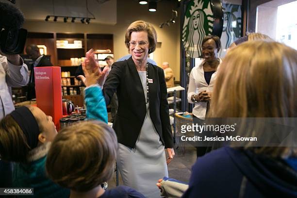 Georgia Democratic U.S. Senate candidate Michelle Nunn gets a high five from young students while visiting a Starbucks to encourages individuals to...