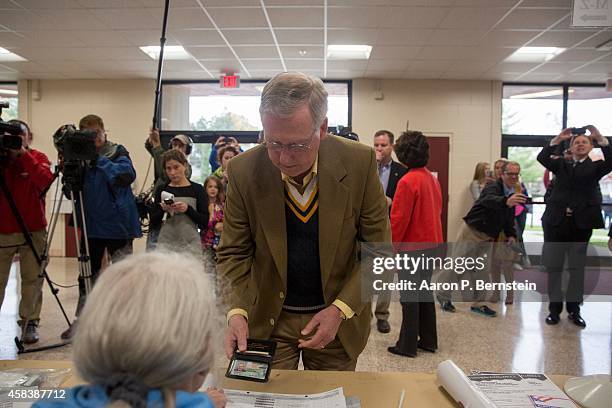 Senate Minority Leader U.S. Sen. Mitch McConnell presents his identification to vote in midterm elections at Bellarmine University November 4, 2014...