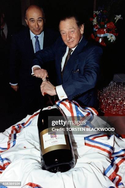 French hotel group Accor chairman Gerard Pelisson opens a bottle of 1992 Beaujolais Nouveau wine on November 18 in Sydney.