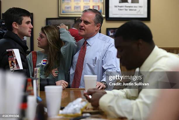 Sen. Mark Pryor talks with his son Adams Pryor and daughter Porter Pryor before having lunch at Sim's BBQ on November 4, 2014 in Little Rock,...