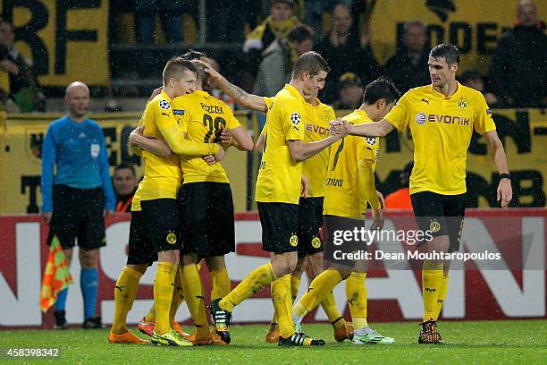 Marco Reus of Borussia Dortmund is congratulated by teammates after scoring the opening goal during the UEFA Champions League Group D match between...