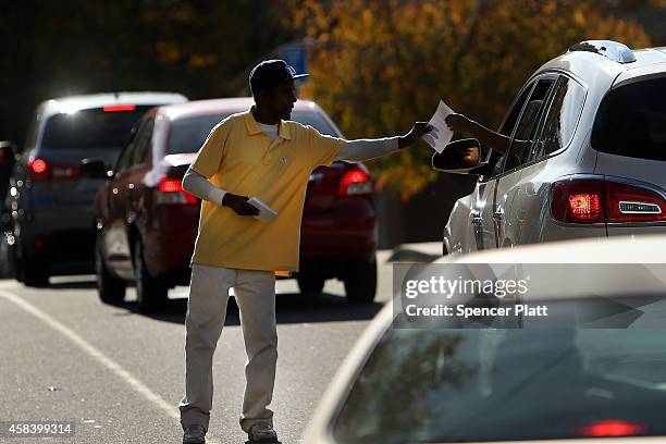Campaign worker passes out campaign literature at a polling station on November 4, 2014 in Bridgeport, Connecticut. Around the country voters are...