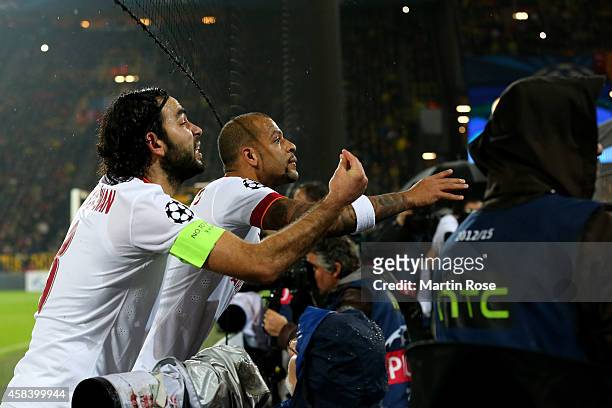 Selcuk Inan of Galatasaray and Felipe Melo of Galatasaray plead with their fans after fireworks are thrown onto the pitch during the UEFA Champions...