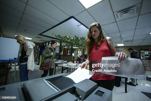 Voter places her election ballot into a electronic voting machine as he votes during the US mid-term elections at a polling station in Dallas, United...