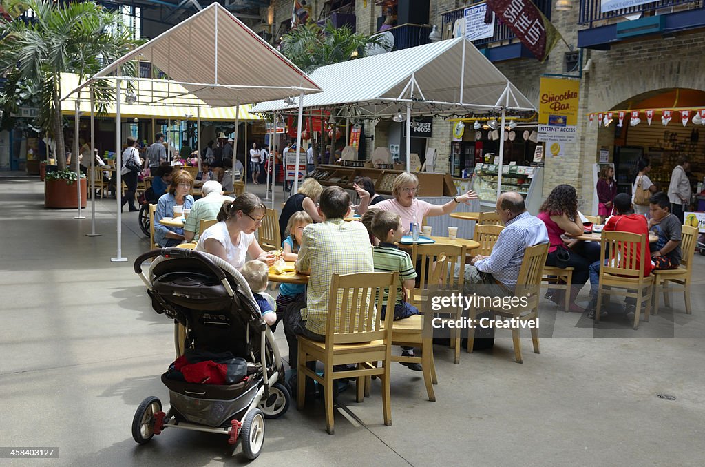 Jeune famille avec les enfants au marché alimentaire cort