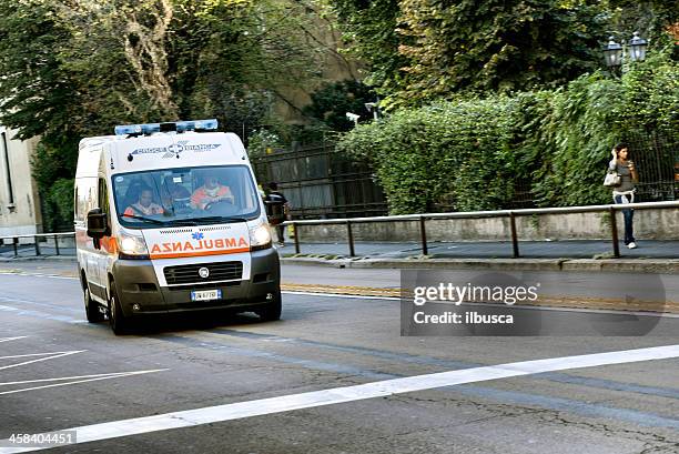 ambulance running fast in milan city centre street - ambulance stockfoto's en -beelden