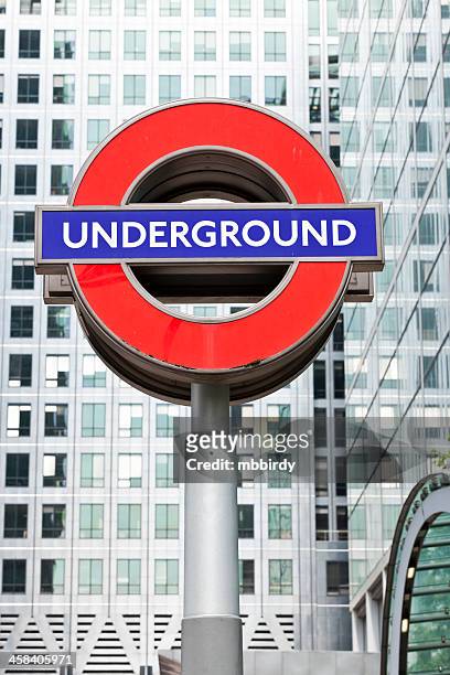 london underground famous sign in canary wharf - london underground sign stockfoto's en -beelden