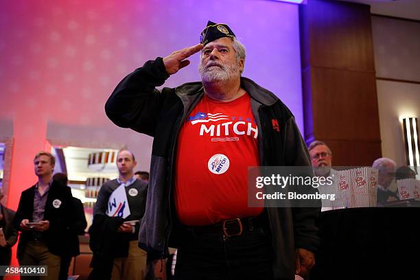 Charles Hayes, an Air Force veteran and supporter of Senate Minority Leader Mitch McConnell, salutes during the National Anthem at a Republican Party...