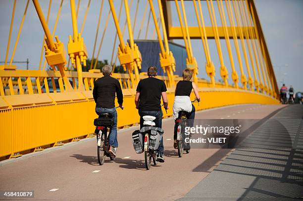 three people cycling on hogeweidebrug in utrecht - utrecht stock pictures, royalty-free photos & images