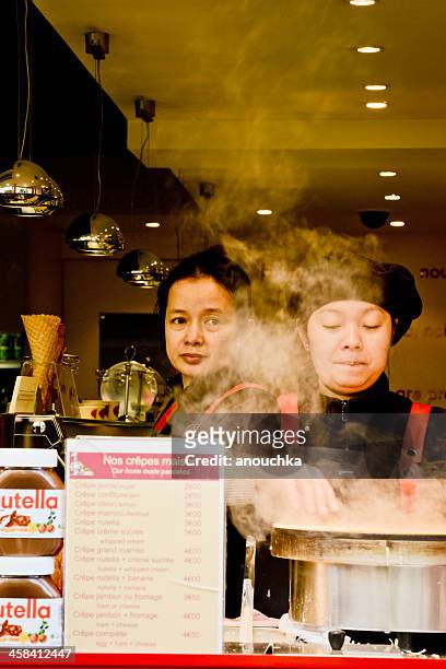 women cooking french crepes outdoors, montmartre, paris - nutella stockfoto's en -beelden