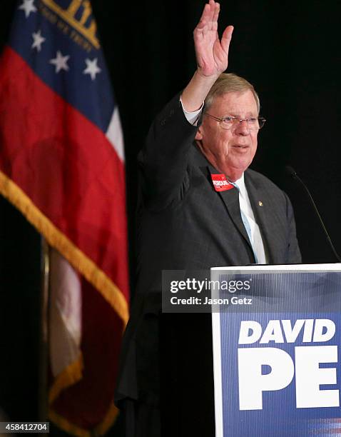 Sen. Johnny Isakson waves to the crowd after he spoke in support of Republican U.S. Senate candidate David Perdue at the InterContinental Buckhead...