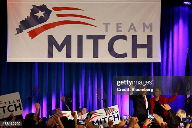 Senate Minority Leader Mitch McConnell, a Republican from Kentucky, second from right, waves to supporters alongside his wife Elaine Chao at a...