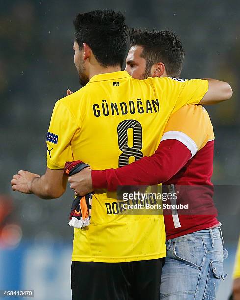 Galatasaray fan hugs Ilkay Guendogan of Dortmund after he runs onto the pitch during the UEFA Champions League Group D match between Borussia...