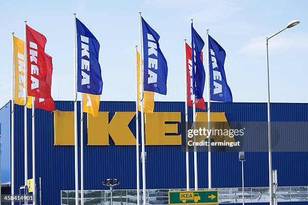 ikea logo on building behind flags - ikea stock pictures, royalty-free photos & images