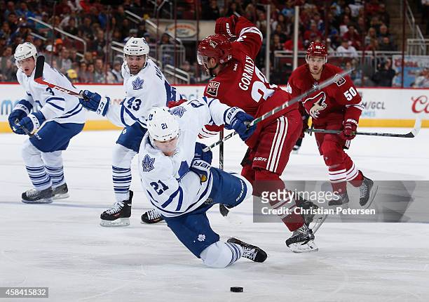 James van Riemsdyk of the Toronto Maple Leafs is tripped up by Brandon Gormley of the Arizona Coyotes for a penalty during the second period of the...