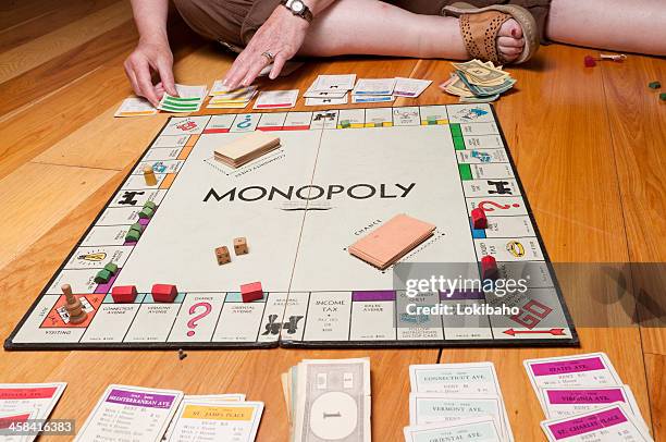 classic monopoly game on the floor midgame - playing board games stock pictures, royalty-free photos & images