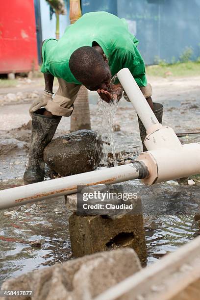 haïtien homme de l'eau potable de bien - haïti photos et images de collection