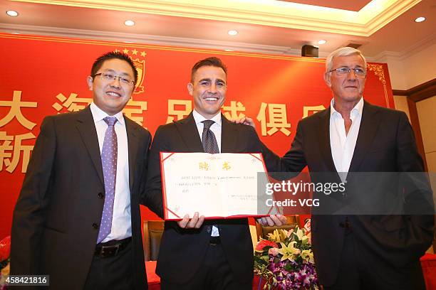 Liu Yongzhuo, Chairman of Guangzhou Evergrande Taobao Football Club, Fabio Cannavaro and Marcello Lippi pose with Fabio Cannavaro's Letter of...