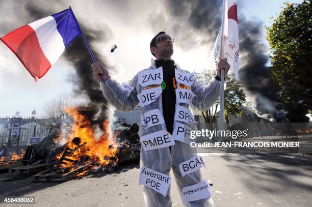 Farmer wearing a suit reading acronyms of the Common Agricultural Policy of the European Union, and waving the French national flag takes part in a...