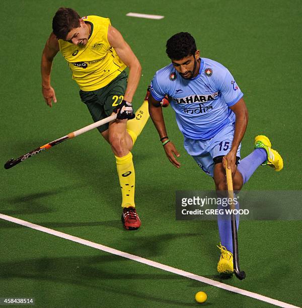Uthappa Sannuvanda runs the ball past Australia's Flynn Ogilivie during the second match of the four match field hockey Test series in Perth on...