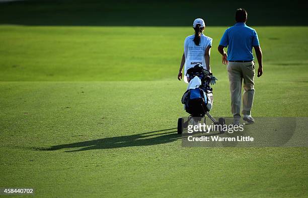 Jason Barnes of England walks with his girlfriend and caddie during the first round of the Dubai Festival City Challenge Tour Grand Final at Al Badia...