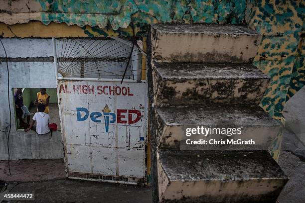 Boys hang out in a destroyed building on the grounds of the Tanauan High School on November 5, 2014 in Tanauan, Leyte, Philippines. Residents of...