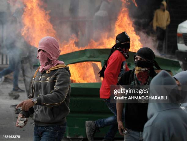 Masked Palestinian protesters clash with Israeli security forces in the Palestinian refugee camp of Shuafat in east Jerusalem, on November 5 after a...