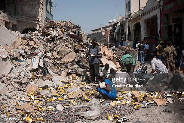menschen sie die batterien in den ruinen - haiti earthquake stock-fotos und bilder