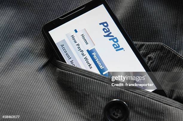 teléfono inteligente con paypal.com logotipo en el bolsillo - paypal fotografías e imágenes de stock