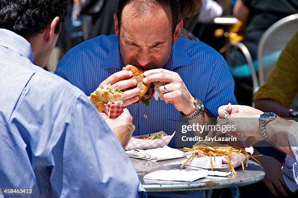 hora del almuerzo al aire libre. macho en hamburguesa de refrigerio. - male burger eating fotografías e imágenes de stock